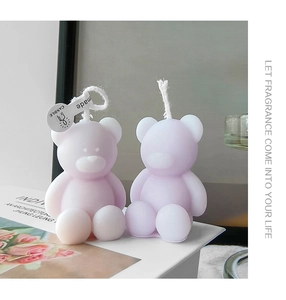 Detail of two lavender bear scented candles on a decorative book for home decor