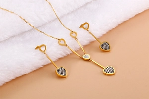 Detail of heart-shaped necklace and earrings set with white shell and crystals
