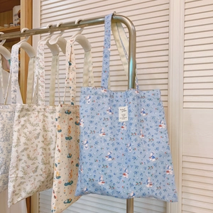 Detailansicht verschiedener blauer Canvas-Stofftaschen mit niedlichen Charakterdrucken