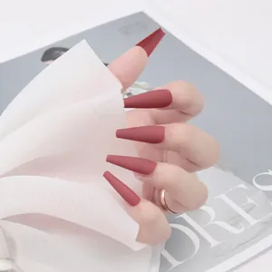 Faux ongles longs forme cercueil marron rouge mat présentés avec un voile de tulle blanc
