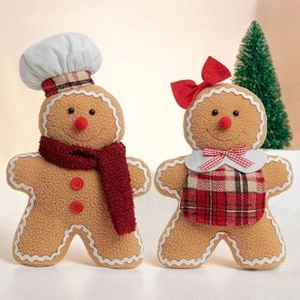 Detail of two plush gingerbread man ornaments with chef hat and plaid apron Christmas decor