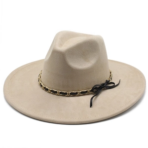 Detail of beige faux suede fedora with gold chain and black bow decoration