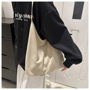 Detail shot of beige faux suede tote bag showing soft texture and large capacity
