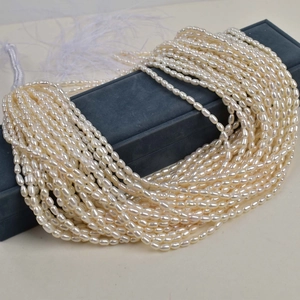 Strands of natural oval freshwater pearls draped over a luxury velvet jewelry storage box