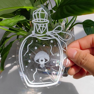 Macro shot of suncatcher window decal featuring mystical potion bottle and butterfly design