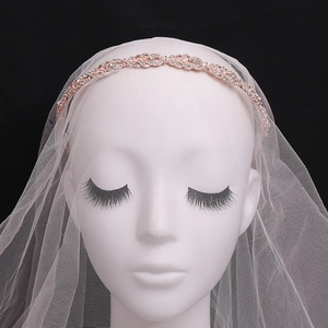 Detail of a sparkling rhinestone tiara headband on a bride with a white mesh wedding veil