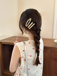 Close-up of marble acetate clip and wavy cream hairpin used in an elegant hairstyle