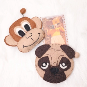 Cute brown monkey and pug dog wool felt coin purses with zippers on white plush background