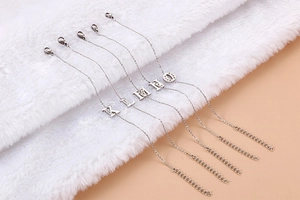 Detail of silver letter pendants K to O on fine chain bracelet with lobster clasp