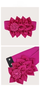 Detail of fuchsia elastic wide belt featuring a large 3D fabric flower with pearl beads