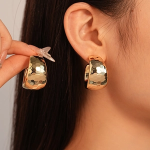 Statement gold-plated hammered metal C-shaped earrings for women with a textured finish
