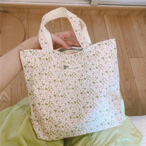 Gros plan d'un sac en coton à fleurs roses avec étiquette textile et fermeture