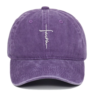 Close-up of cross embroidery and faith lettering on washed purple cotton baseball cap