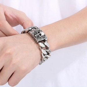 Vintage oxidized silver Cuban link bracelet with skull clasp shown on male model wrist