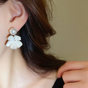 Detail view of flower earrings with freshwater pearls on a model for elegant styling