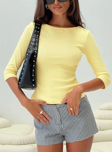 Close-up of light yellow ribbed knit top fabric showing fine texture and crew neck detail