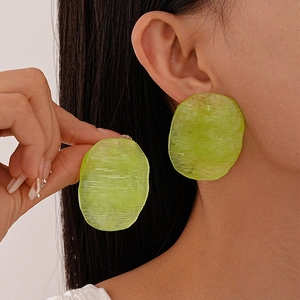 Translucent lime green acrylic oval earrings with textured finish on female model