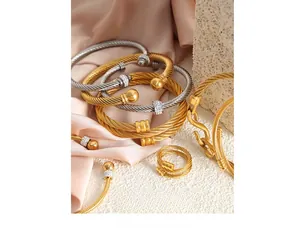 Gros plan de bracelets torsadés en acier inoxydable avec zircons et finition dorée chic