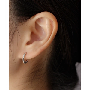 Detailed close-up of a silver S925 sterling silver hoop earring featuring sparkling diamonds