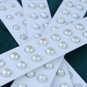 Macro detail of natural white freshwater pearls with high luster on dark velvet