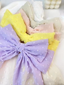 Detail of colorful polka dot chiffon bow hair clips in purple, yellow, and pastel pink