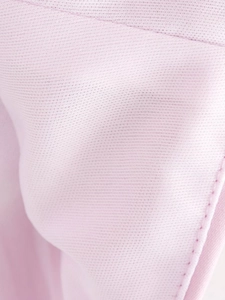 Close-up of light pink breathable mesh fabric texture and delicate stitching detail