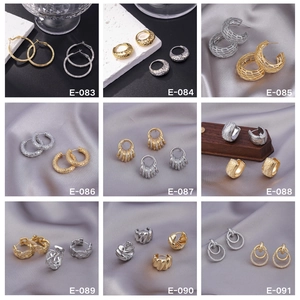 Collage of diverse gold and silver earrings with textured hoops and CZ stud details