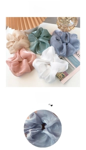 Detailed view of oversized organza scrunchies in five soft colors with glossy texture