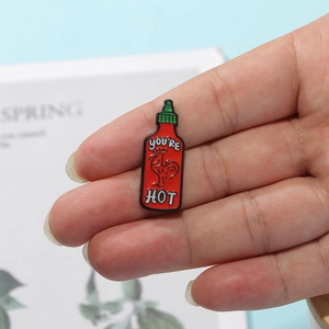 Cute cartoon Sriracha hot sauce bottle enamel pin with 'you're HOT' text and rooster design