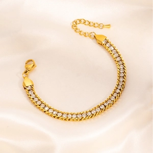 Detailed shot of double-row gold-plated tennis bracelet with white zircons on silk fabric