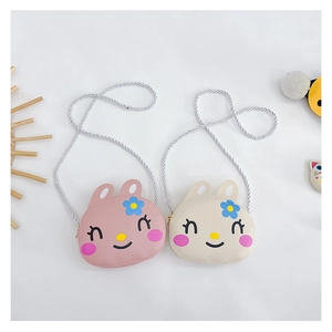 Detail of pink and beige bunny crossbody bags with embroidered faces and woven straps