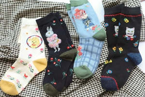Detailed view of assorted cotton socks with forest animal jacquard patterns in four colors