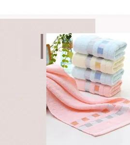Close-up of cotton face towels with checkered border and fine loop texture in four colors