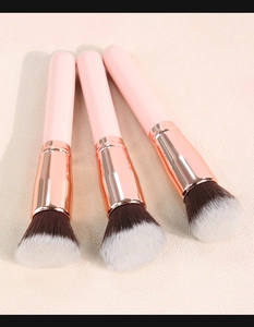 Detailed view of three foundation brushes with pink handles and rose gold metal ferrules