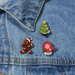 Nahaufnahme von Weihnachtsmann-, Lebkuchen- und Baum-Ansteckern auf einer Jeansjacke