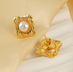 Detail of 18K gold baroque pearl earrings with hammered metal frames and butterfly backs