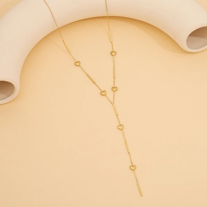 Detailed view of long Y-shaped golden stainless steel necklace with heart and bar charms