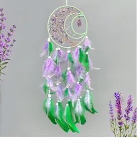 Detail of crescent moon dream catcher with purple crystal stones and green feathers