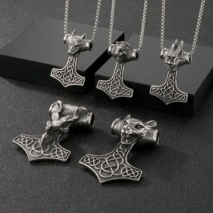 Vue détaillée des pendentifs marteau de Thor viking avec sculptures de têtes d'animaux