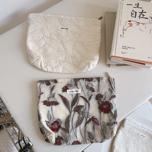 Detailed close-up of French style embroidered fabric pouches with simple wish label