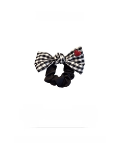 Detail of checkered bow hair scrunchie with a red heart accent and product specifications
