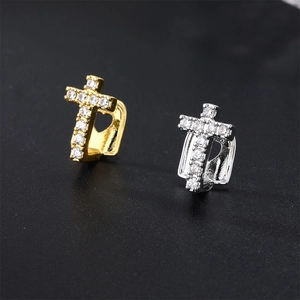Macro view of gold and silver hip hop grillz featuring cross design with cubic zirconia
