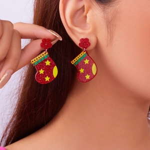 Detail of creative red acrylic Christmas stocking earrings with star and stripe patterns