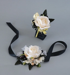 Détails d'une boutonnière et d'un corsage de poignet en rose crème avec rubans noirs
