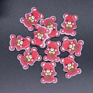 Flat lay of small red resin bear charms with Hug Me text for DIY phone case crafts