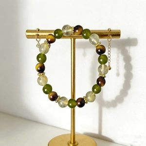 Detail view of multicolored beaded bracelet with gold metal spacer beads on a display stand