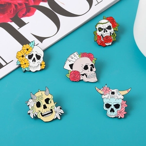 Detail of assorted punk skull enamel pins including rose and bull motifs on blue background