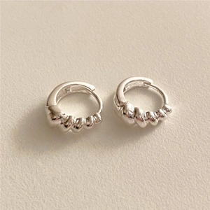 Detailed macro view of S925 sterling silver hoop earrings with French croissant texture