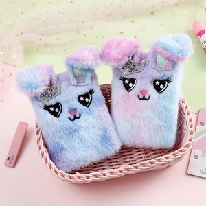 Detail of plush bunny notebooks with tie-dye fur and glitter crown in a pink basket