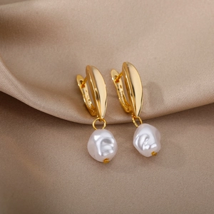 Detailed close-up of baroque pearl earrings on luxury champagne silk fabric background